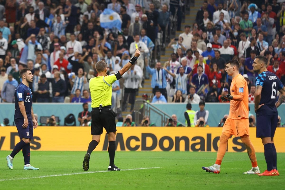 الحكم دانييلي أورساتو يُظهر بطاقة صفراء إلى الكرواتي دومينيك ليفاكوفيتش بعد منح الأرجنتين ركلة-جزاء(رويترز)