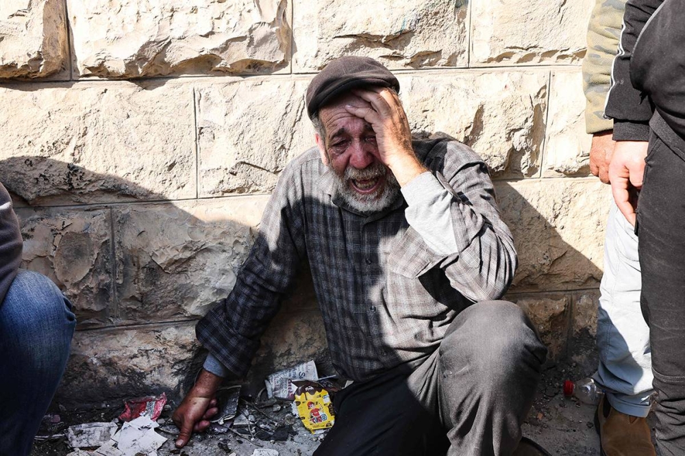 مسن فلسطيني ينعى أحد الضحايا التسعة الذين استشهدوا خلال غارة إسرائيلية على مخيم جنين «AFP»