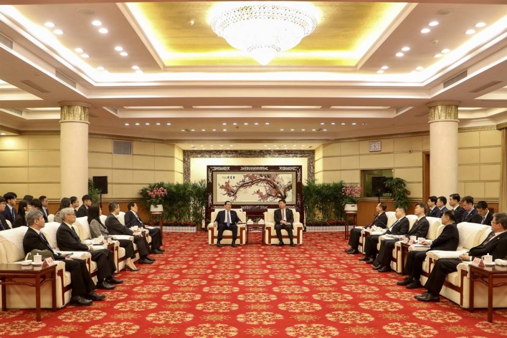 مدير شؤون تايوان دونغ تاو مستقبلاً رئيسها السابق ما ينغ جيو في ووهان أمس (أ ف ب)