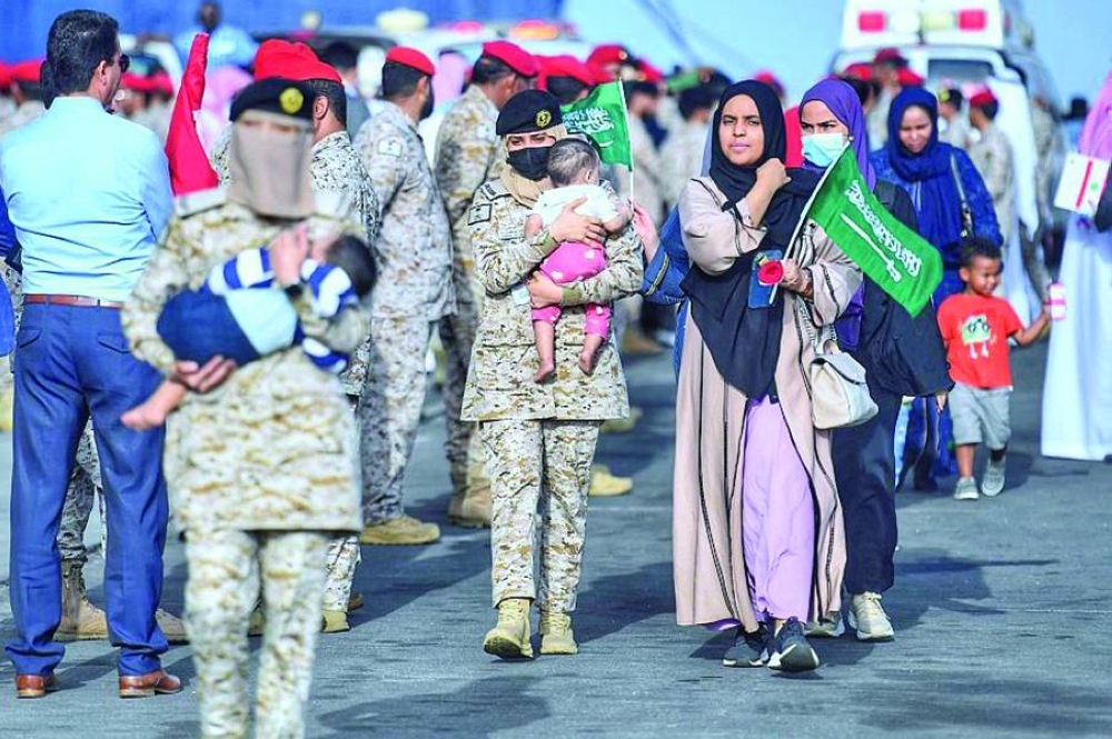 عسكريات سعوديات يساعدن النساء الوافدات إلى جدة أمس (أ ف ب)