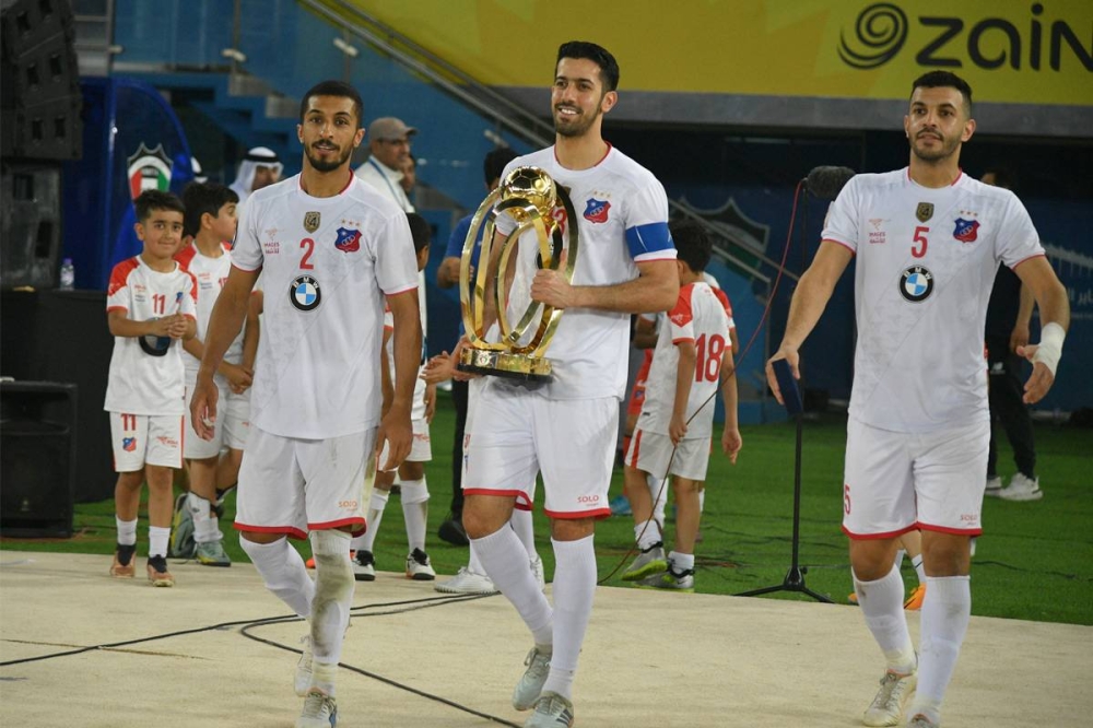 كابتن فريق نادي الكويت فهد حمود حاملاً أغلى الكؤوس