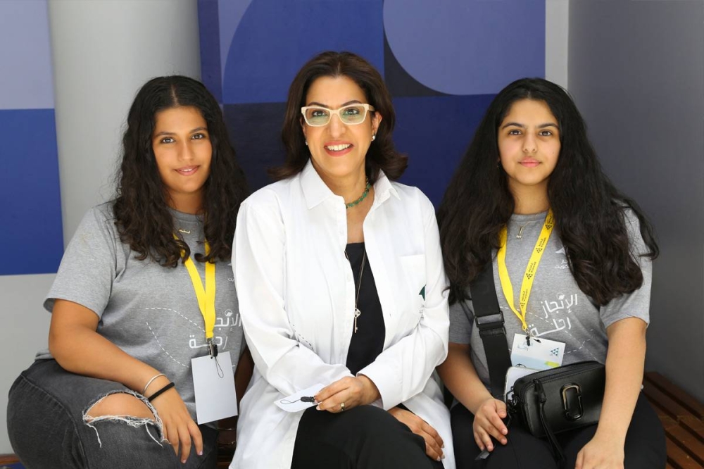 المطيري تتوسط مشارِكتين في البرنامج