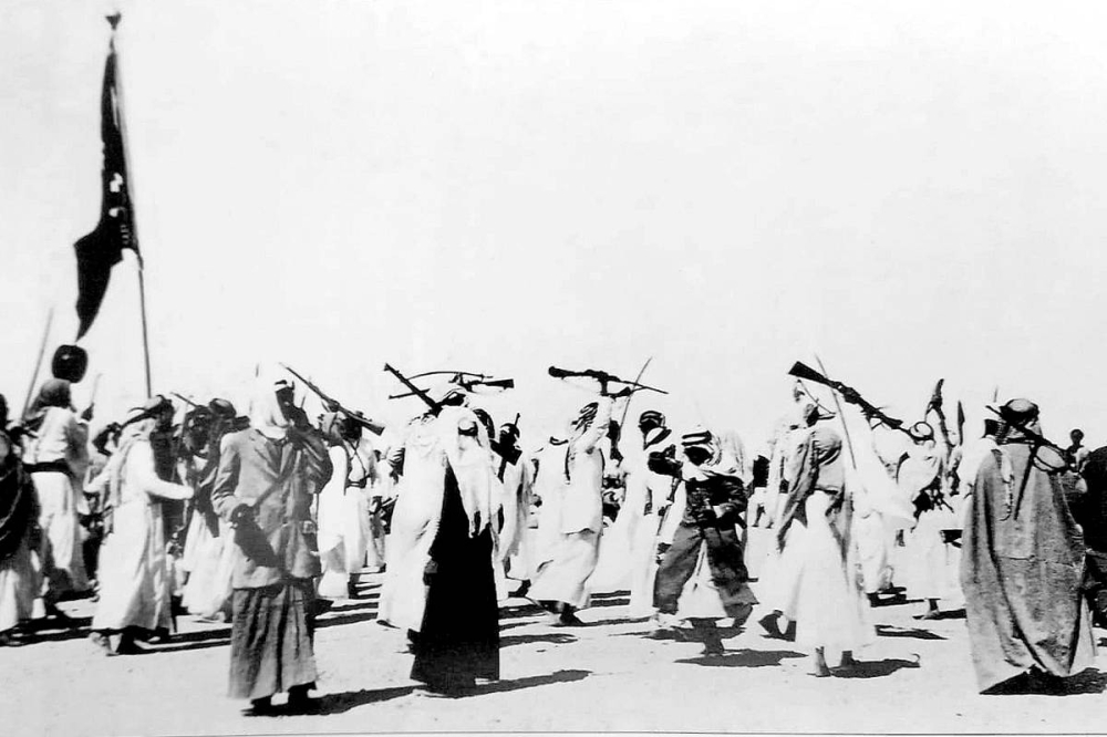 كويتيون يحملون الرماح والبنادق ويرقصون رقصة الحرب عام 1928 نقلاً عن كتاب «الكويت في عيون أوائل المصورين»
