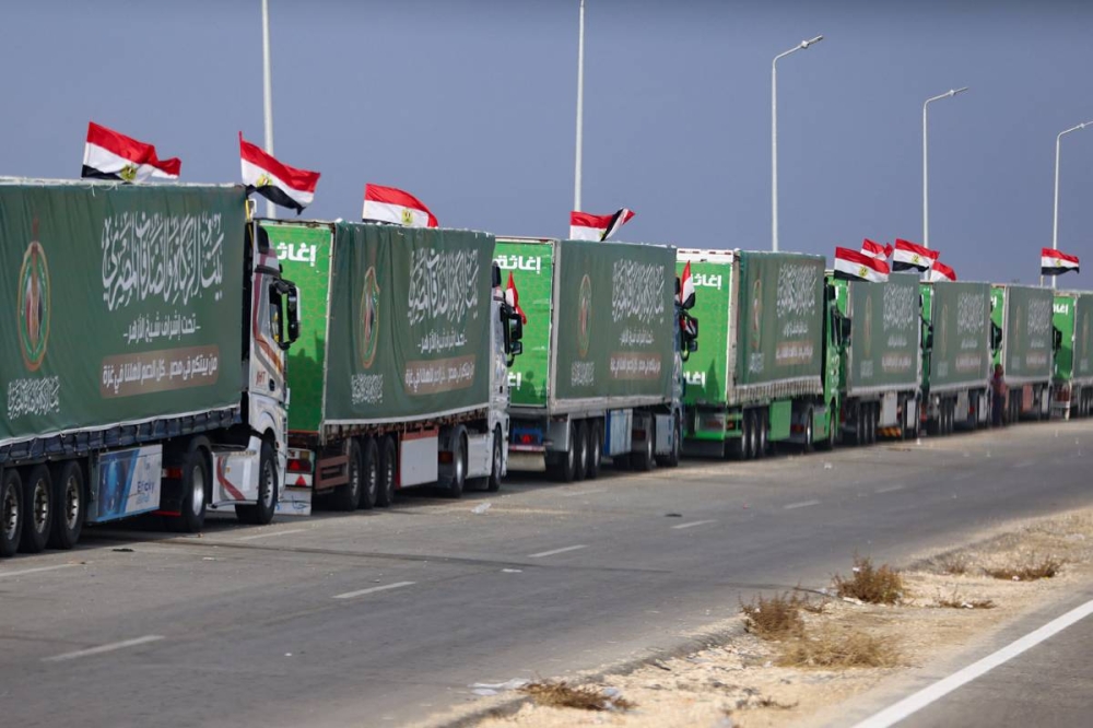 شاحنات تحمل مساعدات على الجانب المصري من معبر رفح أمس (رويترز)