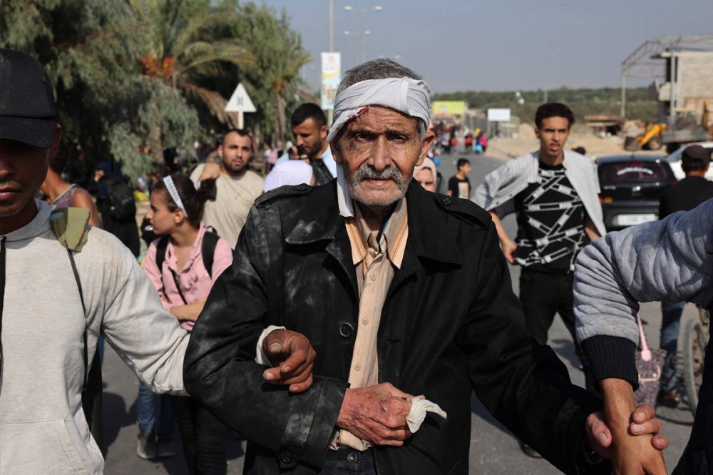 فلسطينيون يغادرون غزة سيراً على الأقدام باتجاه جنوب القطاع أمس (أ ف ب)