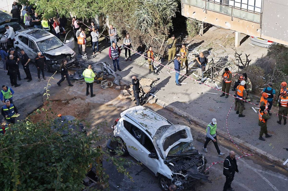 إسرائيليون في محيط منطقة سقطت بها صواريخ فلسطينية جنوب تل أبيب أمس (رويترز)