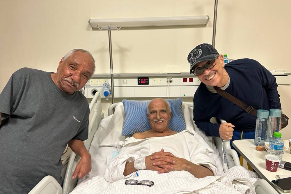 الراحل على سرير المرض متوسطاً حسن العيسى وعبداللطيف الدعيج