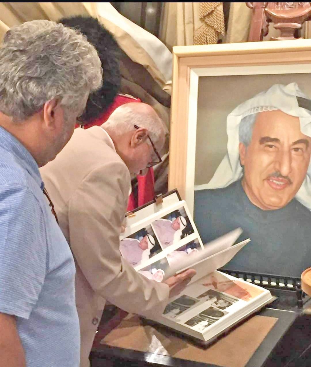 الفقيد متصفحاً الذكريات أمام بورتريه لأخيه خالد الزيد
