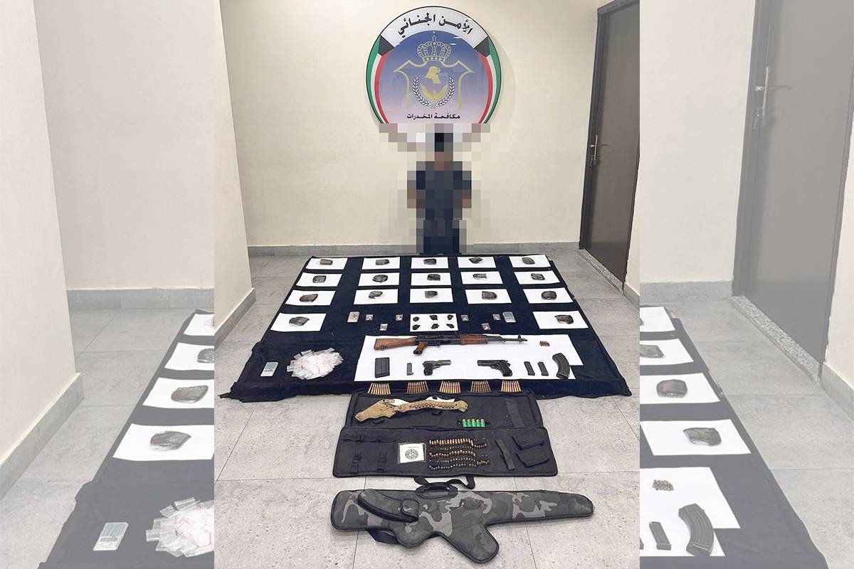 أحد المتهمين المضبوطين وأمامه المواد المخدرة والأسلحة النارية