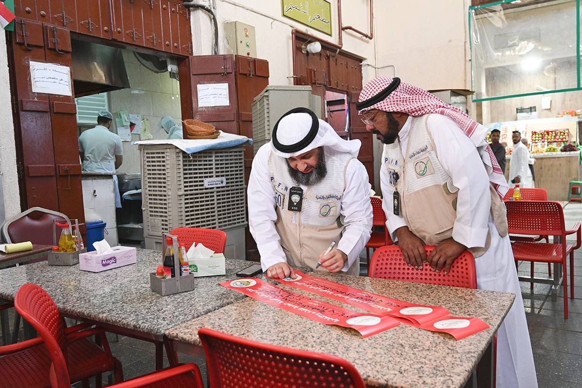 الكندري خلال إعداد ملصقات الإغلاق (تصوير نوفل إبراهيم)