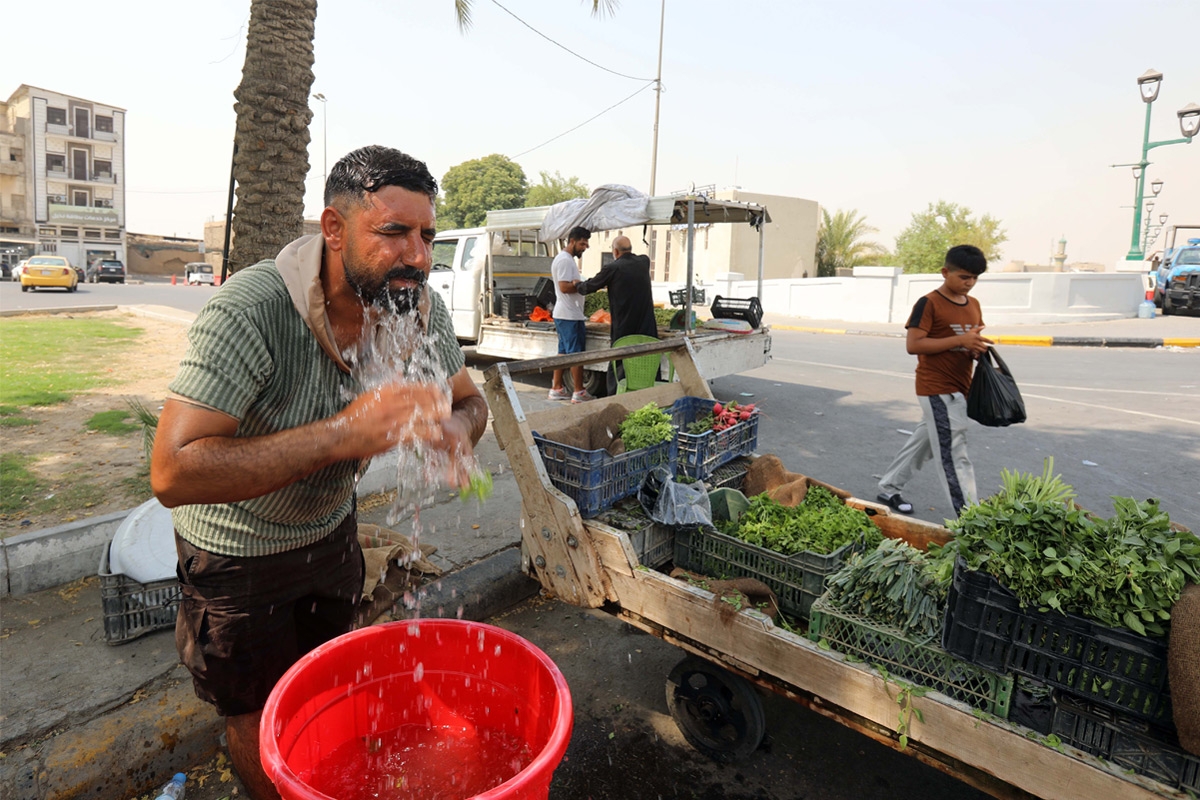 مواطن عراقي يبرد نفسه وسط موجة حر في بغداد