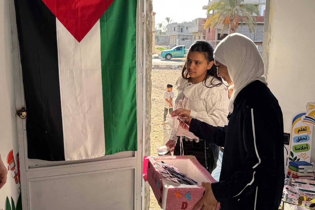 المعلمة الفلسطينية هديل زعرب تقف عند باب فصل دراسي في مدرسة للأطفال الفلسطينيين النازحين من غزة، في مدينة العريش المصرية، في 1 أكتوبر 2026. (فرانس برس)