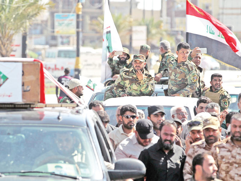 عناصر في «سرايا السلام» أمس في مدينة الصدر ببغداد، خلال تشييع أحد قتلى اقتحام المنطقة الخضراء 