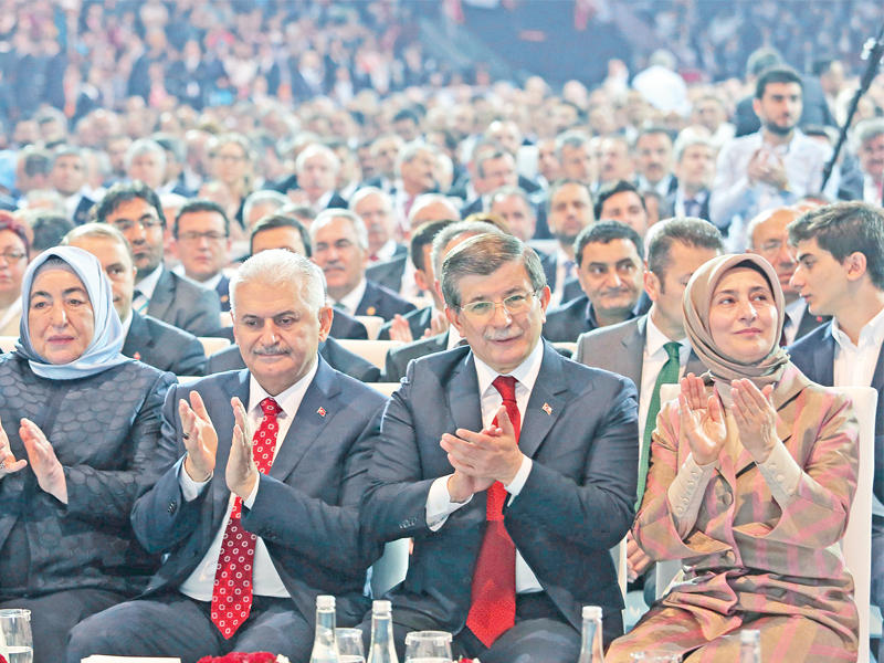  يلدريم وزوجته سميحة إلى جانب داود أوغلو وزوجته ساري خلال المؤتمر أمس 