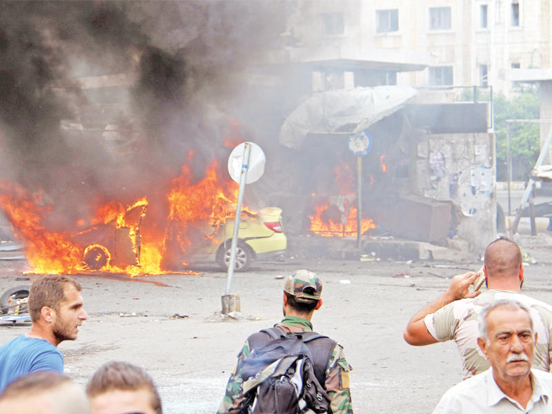 مسؤولون ومدنيون يتفقدون عن بعد أضرار تفجير محطة حافلات طرطوس أمس  (إي بي إيه)