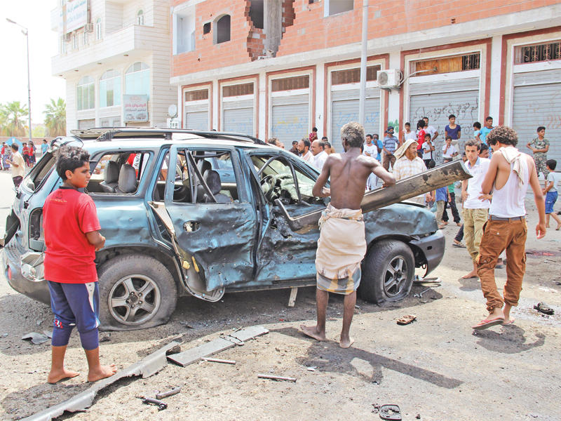 يمنيون يعاينون موقع تفجير عدن أمس (رويترز)