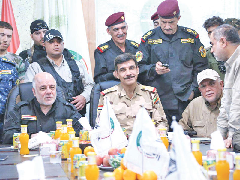 العبادي مترئساً اجتماعا بالقيادات العسكرية في غرفة عمليات الفلوجة أمس، ويبدو العامري جالساً إلى طاولة الاجتماع