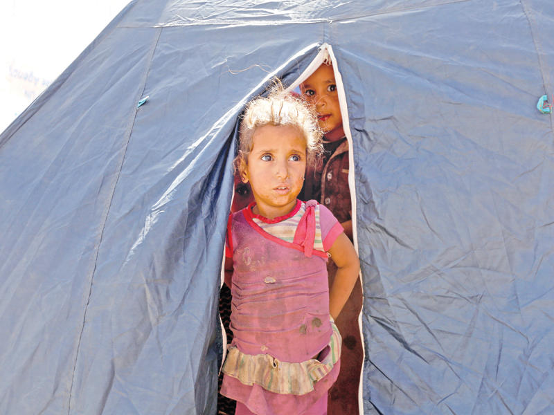 طفلان  يمنيان داخل خيمة بمخيم للمهجرين في صنعاء أمس (رويترز)