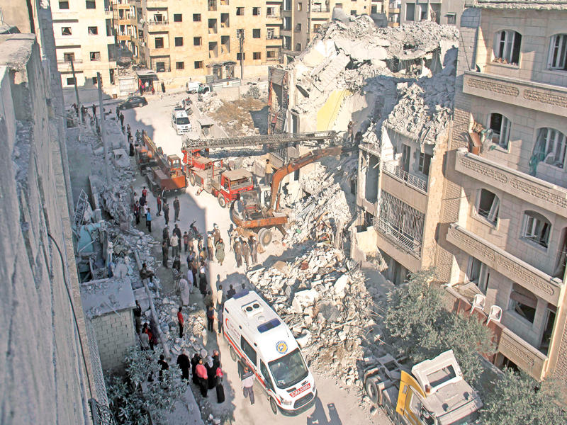 عاملون إنسانيون يحاولون العثور على ناجين أمس في موقع تعرض للغارات في وقت متأخر من مساء أمس الأول (أ ف ب)