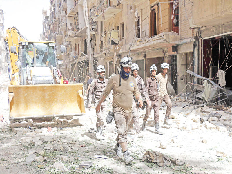 أصحاب الخوذات البيضاء يبحثون عن ناجين وسط حطام مبان دمرتها غارات النظام على حي السكري في حلب أمس الأول (أ ف ب)