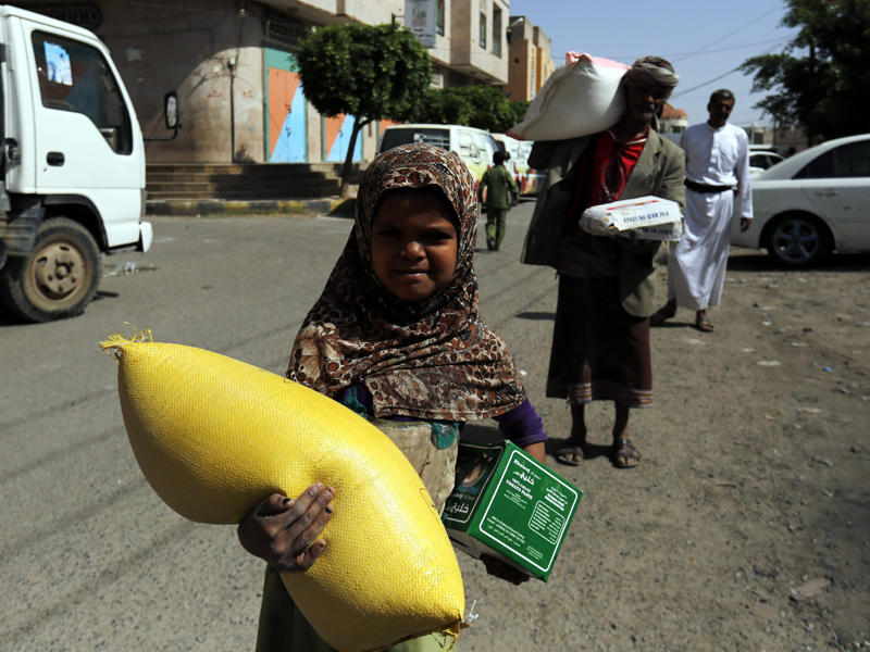 طفلة تتلقى مساعدات غذائية في صنعاء