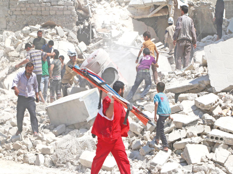 صبية يشاركون في البحث عن ناجين تحت أنقاض مبنى دمرته غارات النظام أول أيام رمضان في حي المرجة بحلب  (رويترز)