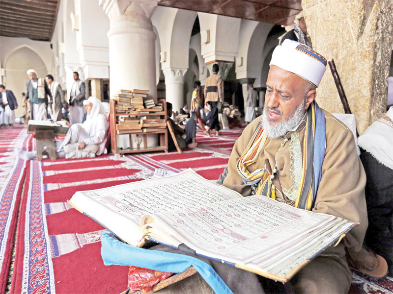 يمني يقرأ القرآن الكريم بالمسجد الكبير في صنعاء القديمة أمس الأول             (إي بي أيه)