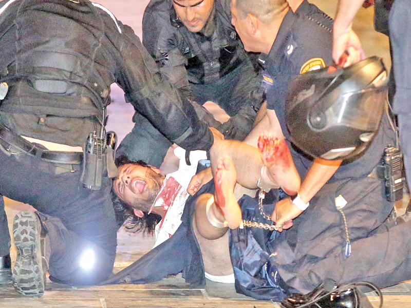 الشرطة الإسرائيلية تعتقل أحد منفذي هجوم تل أبيب خلال فراره من موقع الهجوم مساء أمس الأول (أ ف ب)