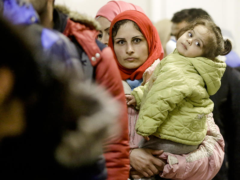 لاجئة تحمل ابنتها في مدينة ميونخ الألمانية