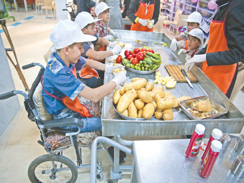 صبي سوري مصاب في قصف نظامي يشارك في مسابقة لإعداد وجبات إفطار في دوما أمس الأول (أ ف ب)