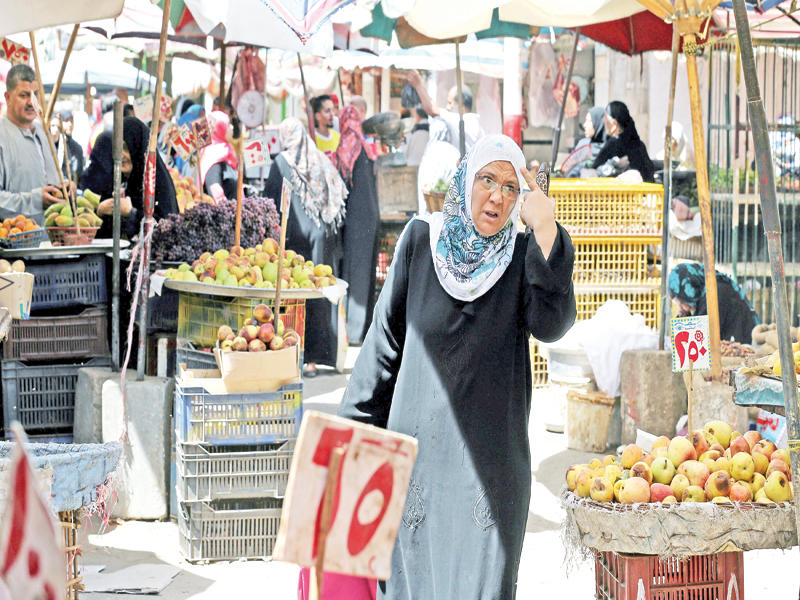 مصريون في سوق شعبي للخضراوات والفاكهة بالقاهرة (رويترز)