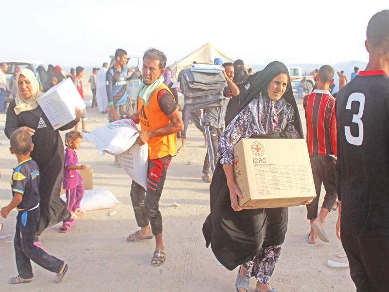نازحون عراقيون من الرمادي يتلقون مساعدات دولية قبل أيام في الحبانية (أ ف ب)