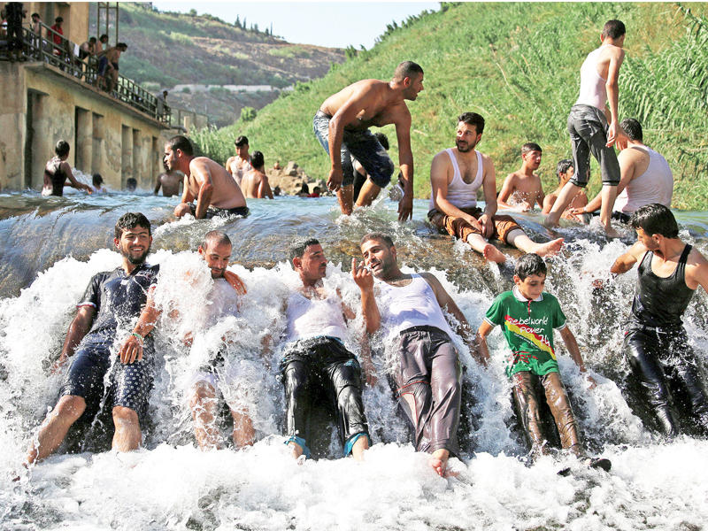 سوريون يواجهون الحر ببرودة مياه نهر غلين في درعا أمس الأول