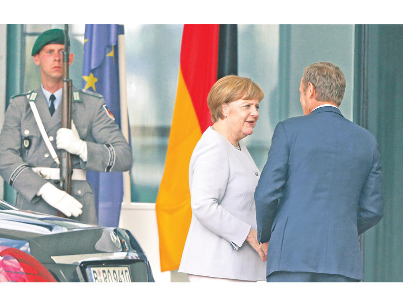 ميركل مستقبلة رئيس البرلمان الأوروبي دونالد توسك في مقر المستشارية ببرلين أمس (رويترز)n