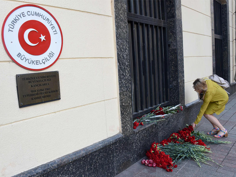 روسية تضع الورد أمام السفارة التركية تضامناً مع ضحاياً تفجير مطار أتاتورك