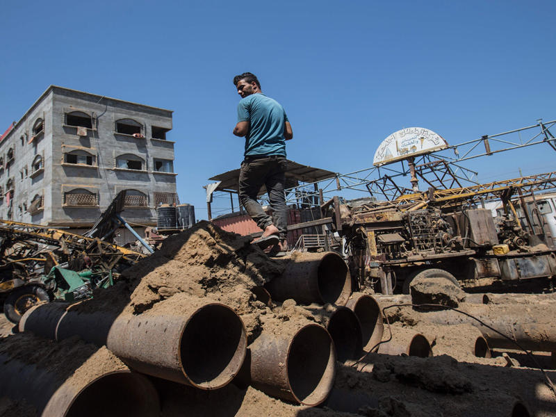 شاب فلسطيني يعاين الأضرار في ورشة الحدادة التي تم قصفها