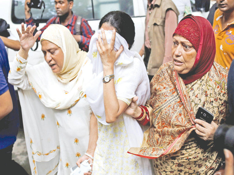 قريبات ضحايا هجوم دكا ينتحبن قرب مطعم هولي ارتيزان بيكري أمس (رويترز)