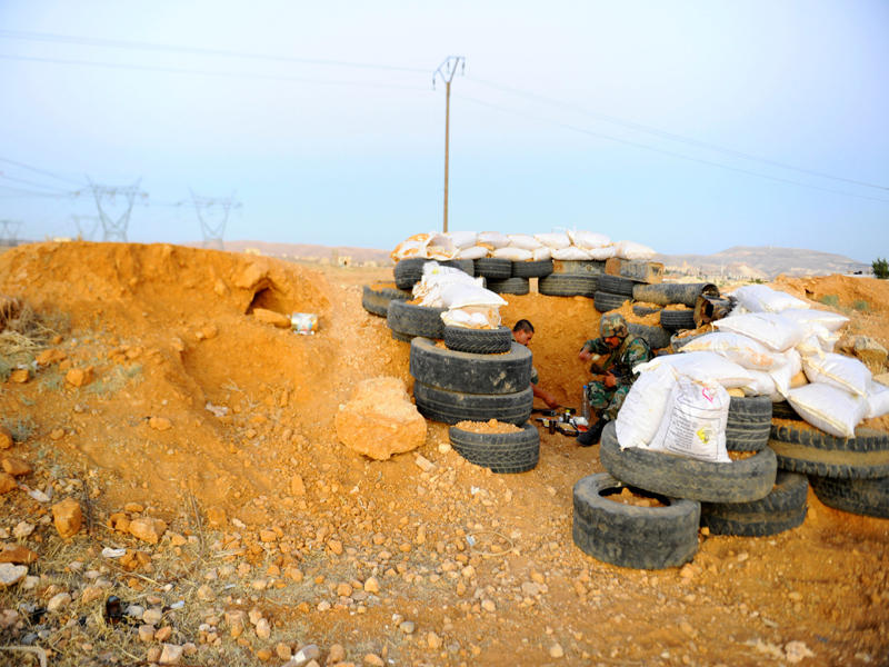 مجندان يتناولان الإفطار داخل معسكر تدريب في دمشق في 26 يونيو (رويترز) 