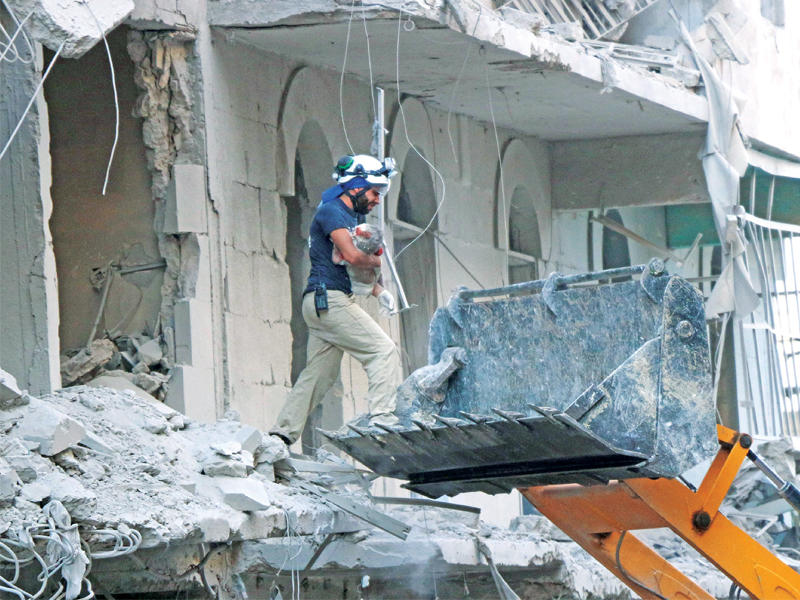 عامل إنقاذ يجلي بمساعدة «لودر» حفر طفلاً قتل في قصف نظامي جديد على حي طارق الباب بحلب أمس الأول (أ ف ب)