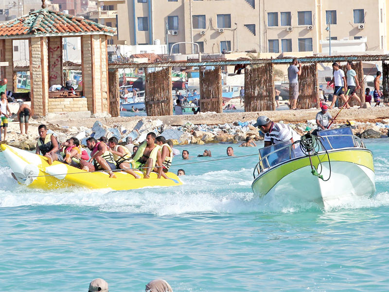 مصريون على شاطئ مدينة مرسى مطروح في ثاني أيام عيد الفطر أمس الأول (إي بي أيه)