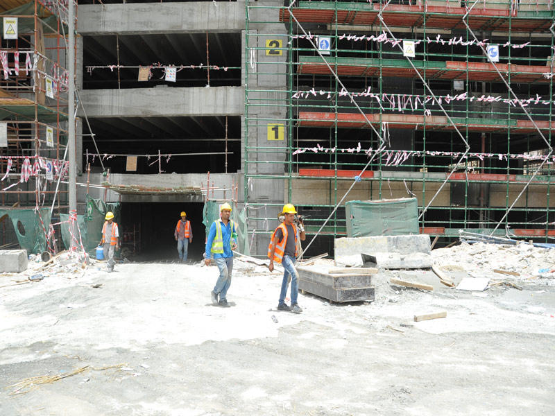 صورة أرشيفية للعمل وقت الظهر  وفي الإطار عامل يبرد نفسه بالماء