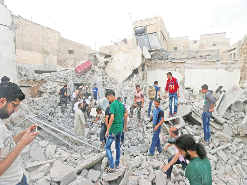 سوريون يبحثون عن ناجين تحت أنقاض مبان دمرها النظام في حي قاضي عسكر بحلب أمس الأو ل  (رويترز)