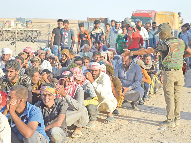 نازحون ينتظرون الفحص الأمني من القوات العراقية بطريقة مسيئة في منطقة بحيرة الثرثار شمال غرب بغداد أمس الأول (رويترز)