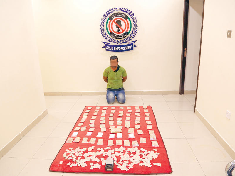 المتهم وأمامه المضبوطات