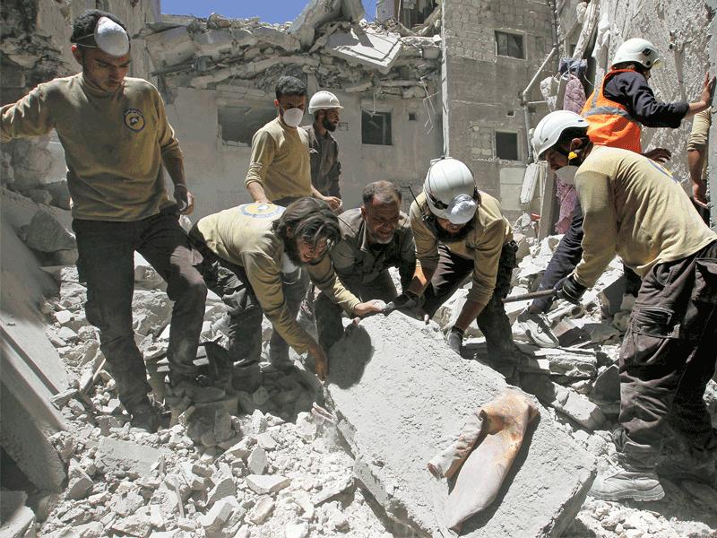 مسعفون يحاولون البحث بين الركام عن أحياء بعد غارة على بلدة أريحا في إدلب أمس أوقعت 11 قتيلاً (رويترز)