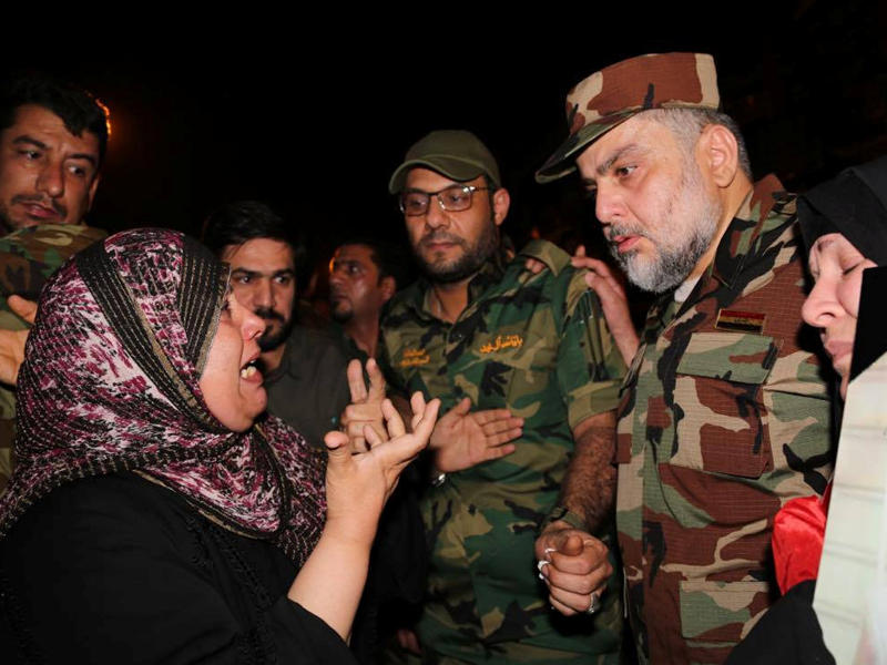 الصدر بالزي العسكري في موقع تفجير الكرادة يستمع إلى شكوى اثنتين من أمهات الضحايا مساء أمس الأول