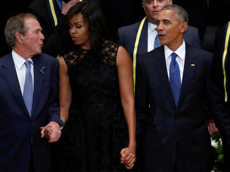 بوش يحاول دفع السيدة الأولى إلى التمايل معه على الموسيقى خلال تأبين ضحايا دالاس مساء أمس الأول (رويترز)