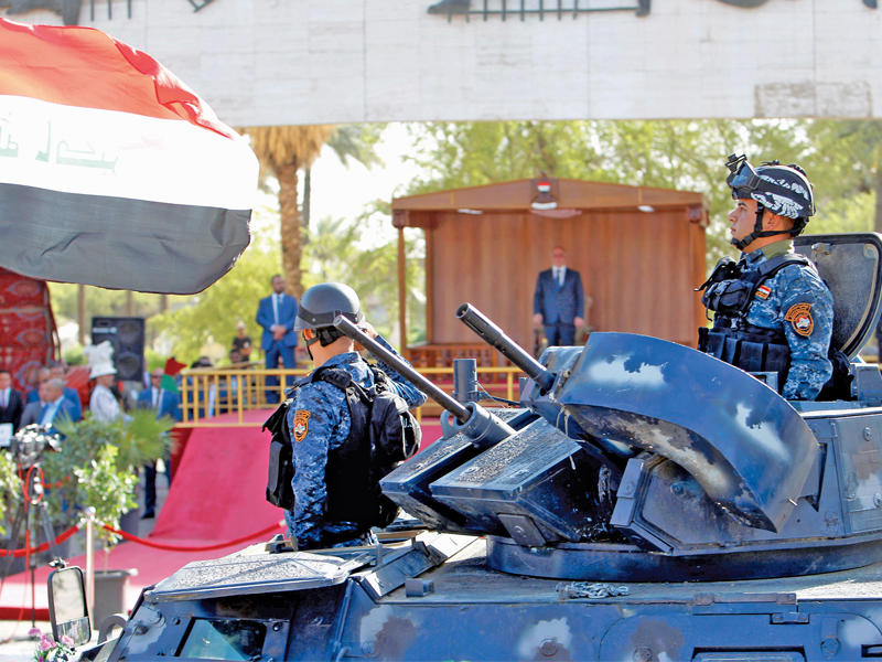 العبادي يحيي قطاعات الجيش و«الحشد» وحيداً على المنصة في ساحة التحرير وسط بغداد أمس (رويترز)n