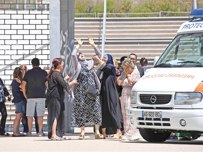 امرأة من أصول عربية تبكي حفيدها الذي قضى في الهجوم أمام مستشفى باستور في نيس أمس ( أف ب)