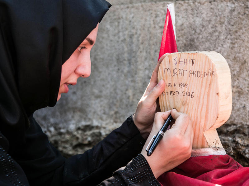 قريبة أحد ضحايا الانقلاب تكتب إسمه على شاهد قبره
